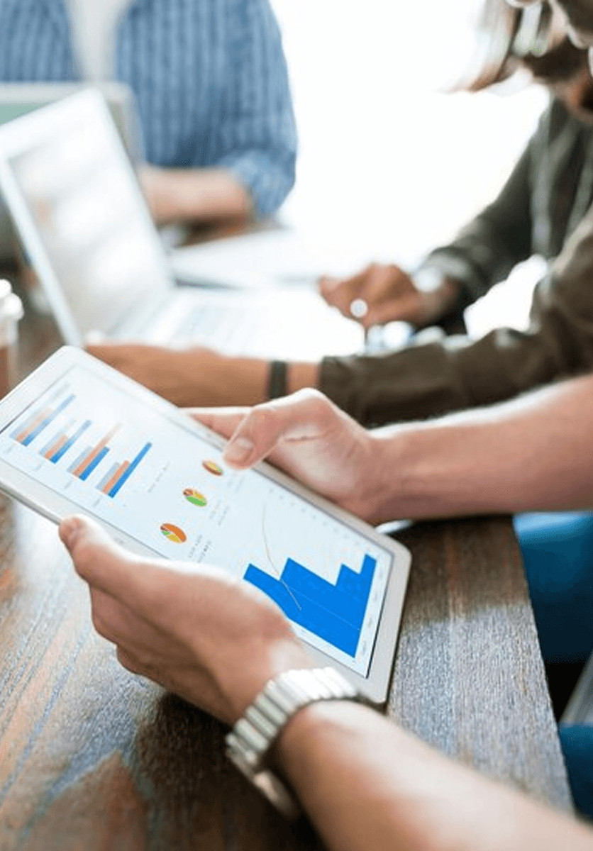 Team members reviewing analytics charts on a tablet during a meeting.
